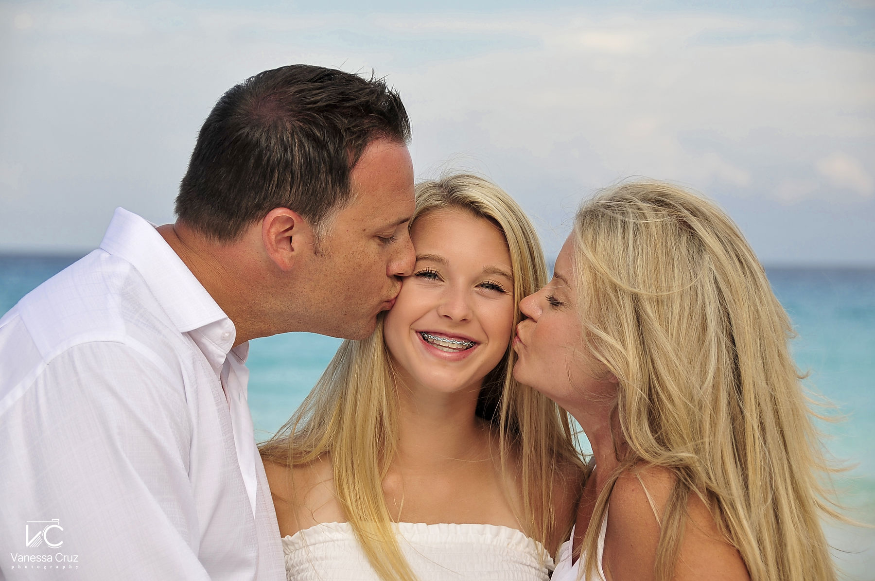 Mom and dad kissing daughter Cancun Mexico