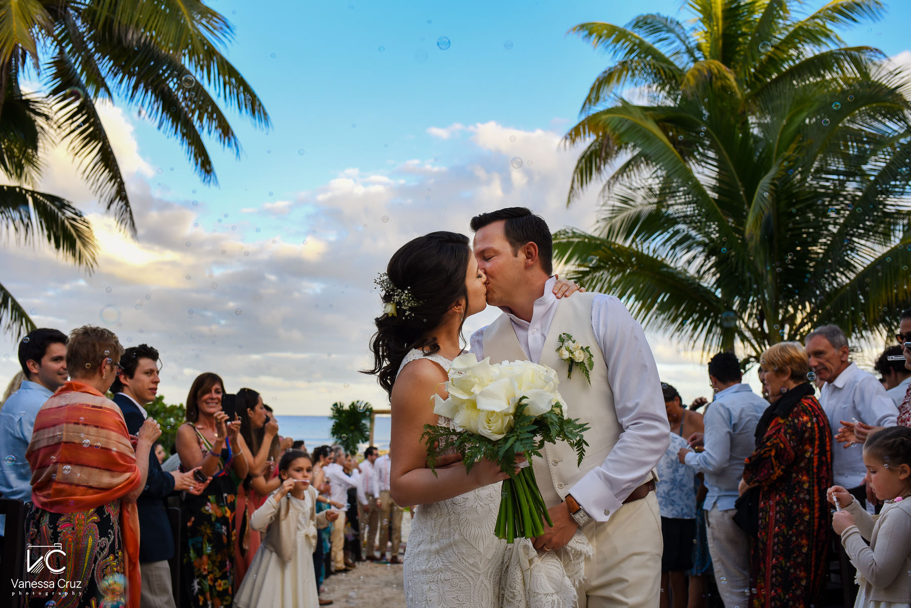 bride and groom kissing guest celebrating she said i do blue Venado Riviera Maya Mexico