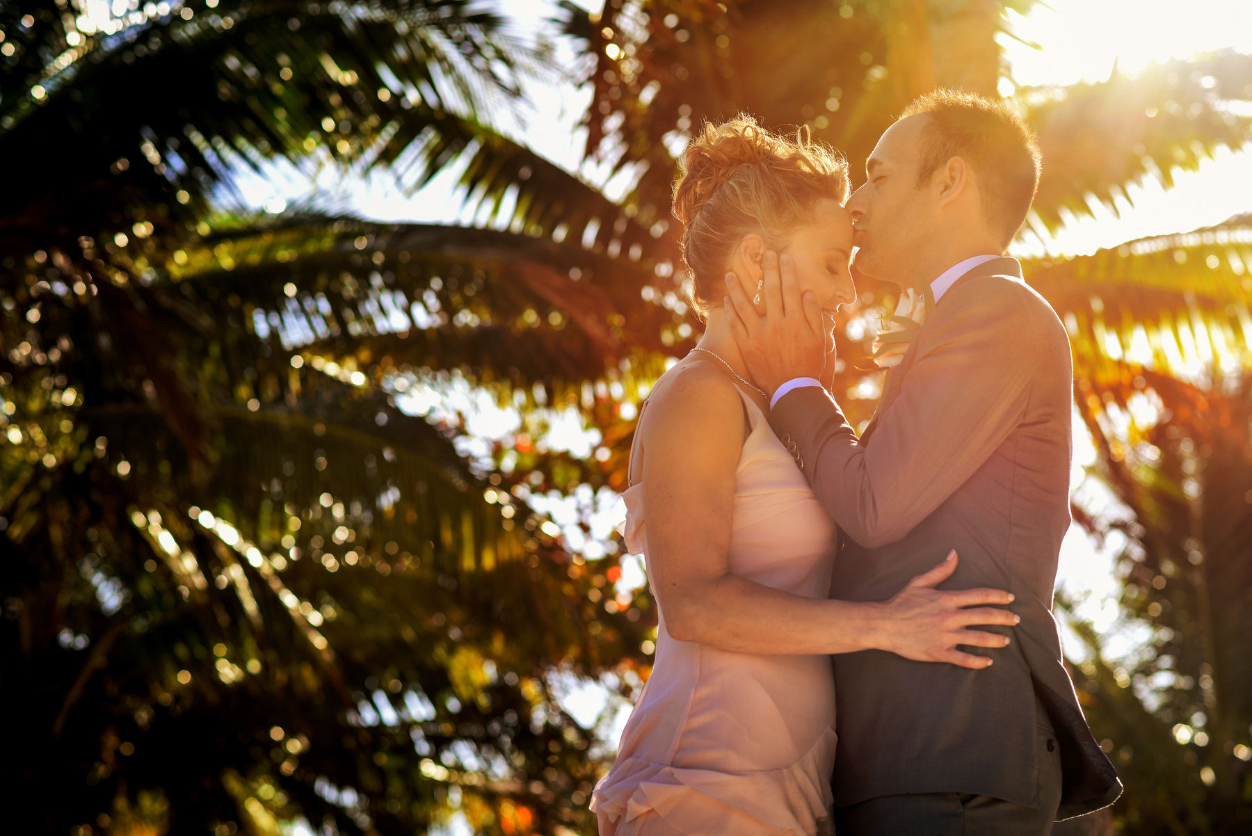 Groom kissing bride sunset wedding portrait Puerto Aventuras Mexico 